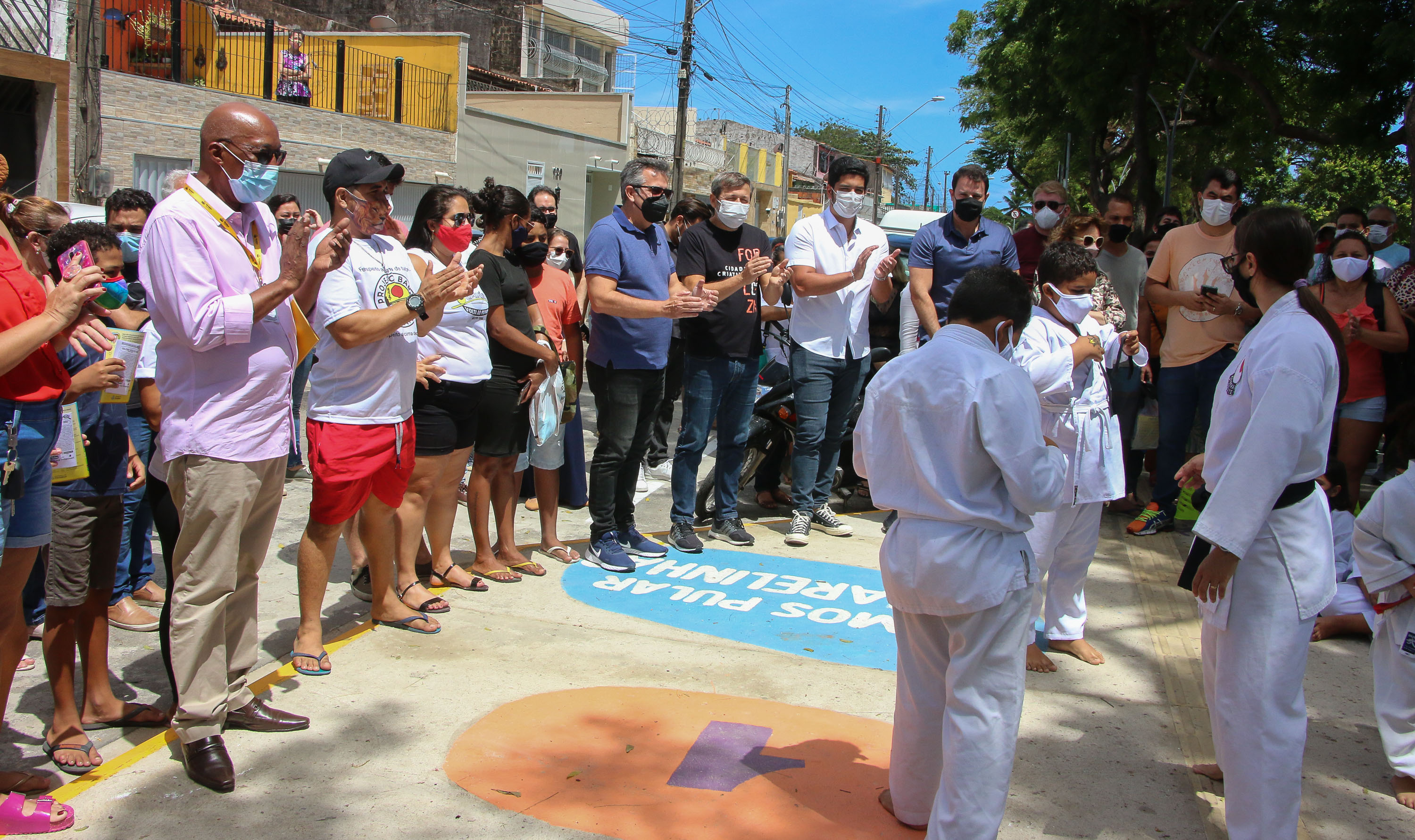 crianças praticam artes marciais no micro parque diante de um grupo que assiste à atividade